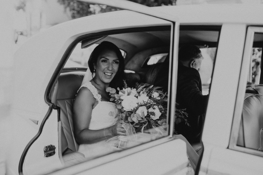 black and white portrait of the bride arriving in santa Trofimena church in Amalfi by a classic car