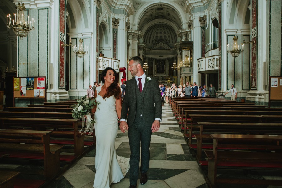Bride and groom walking down the aisle of Santa Trofimena church in Amalfi