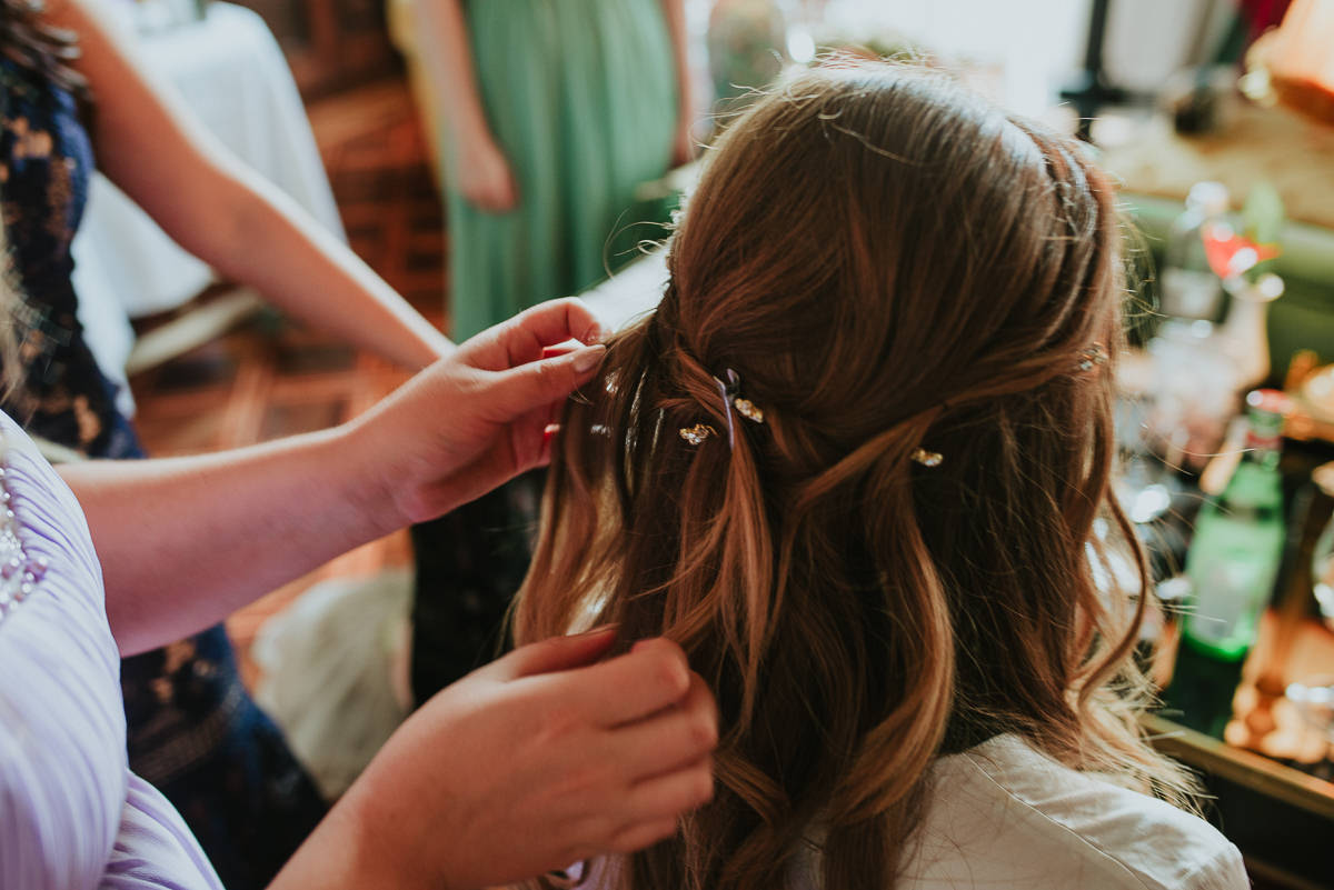 bride gets her hair done before wedding