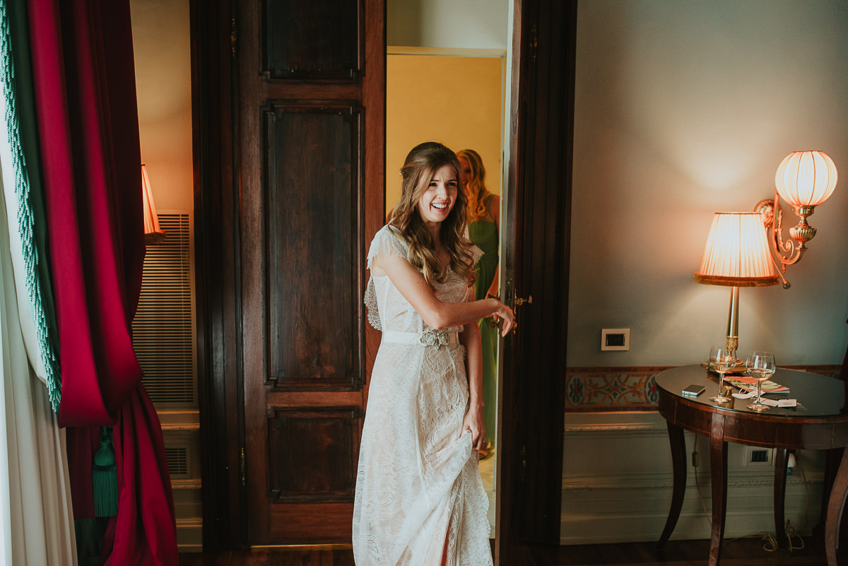 brides exit her room for the first look with the bridesmaids and parents