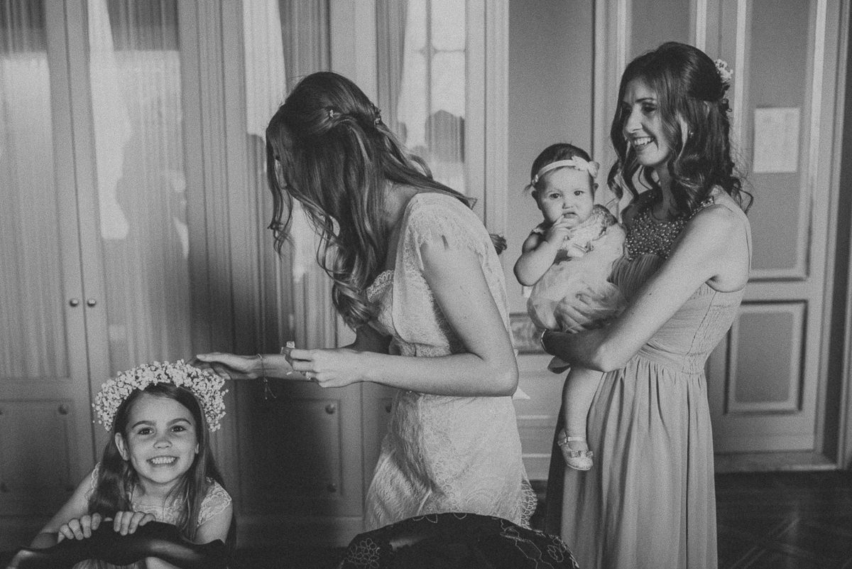 black and white portrait of bride and sister and smiling kids