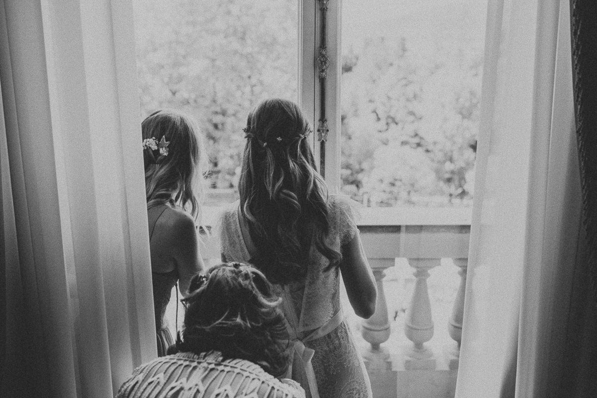 bride looking out of the window of her room before wedding