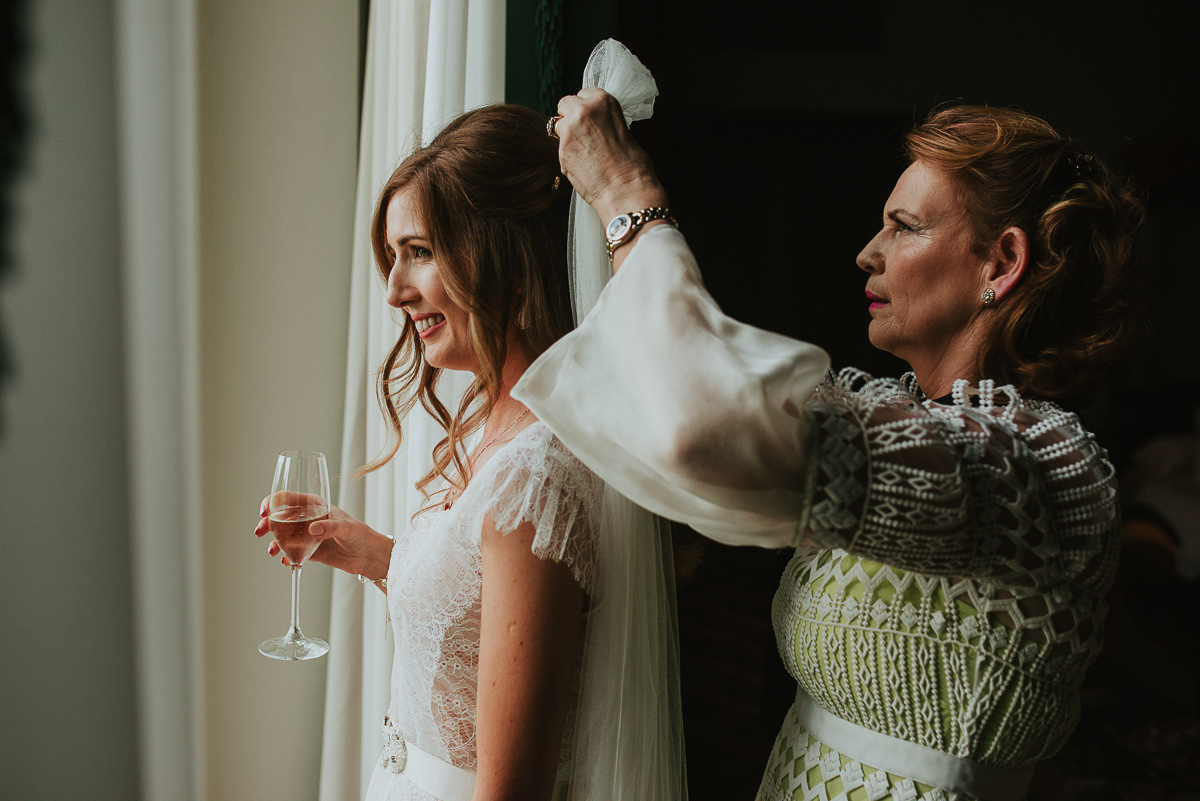 mother puts the veil on the bride