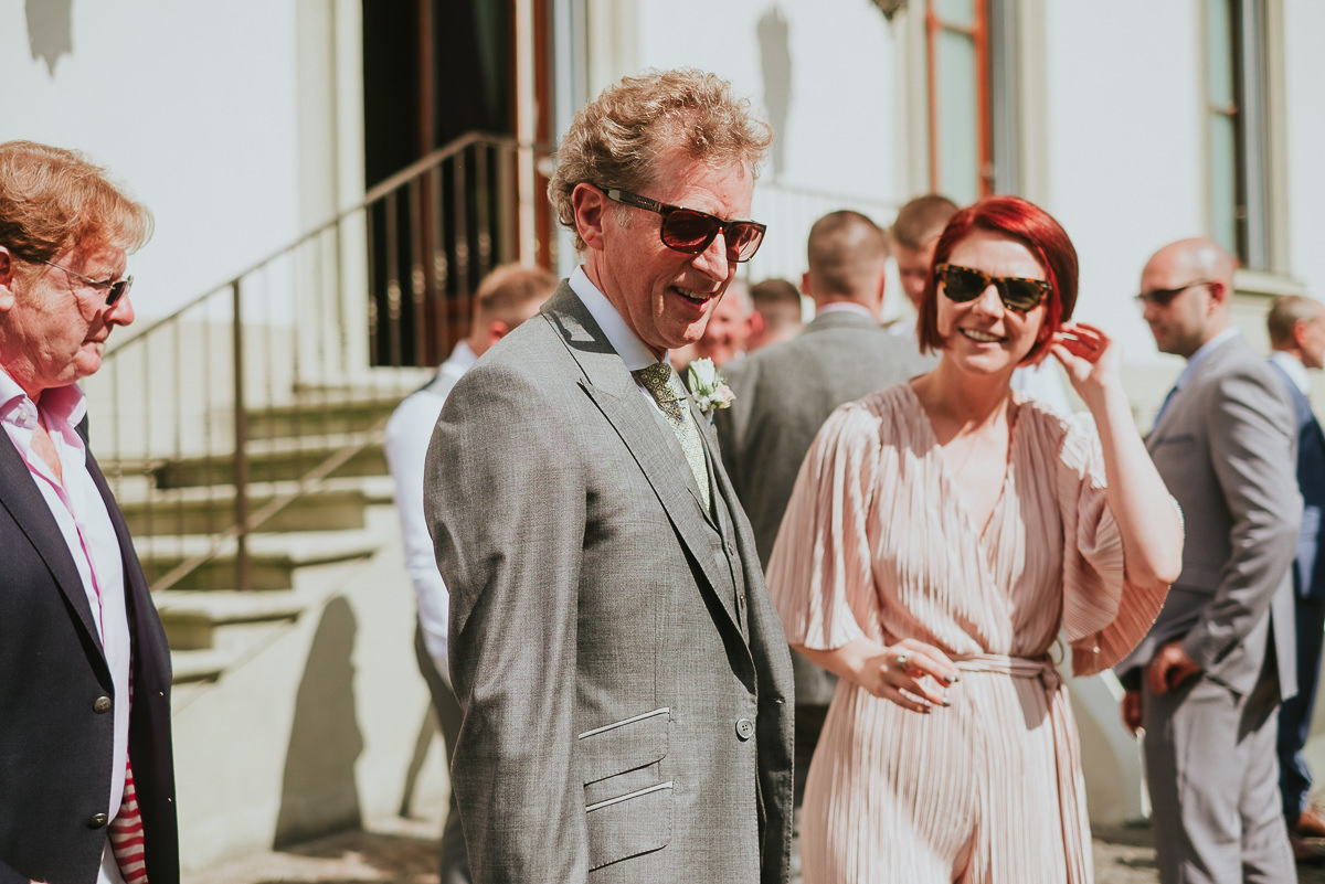father of the bride in front of villa cora wearing sunglasses