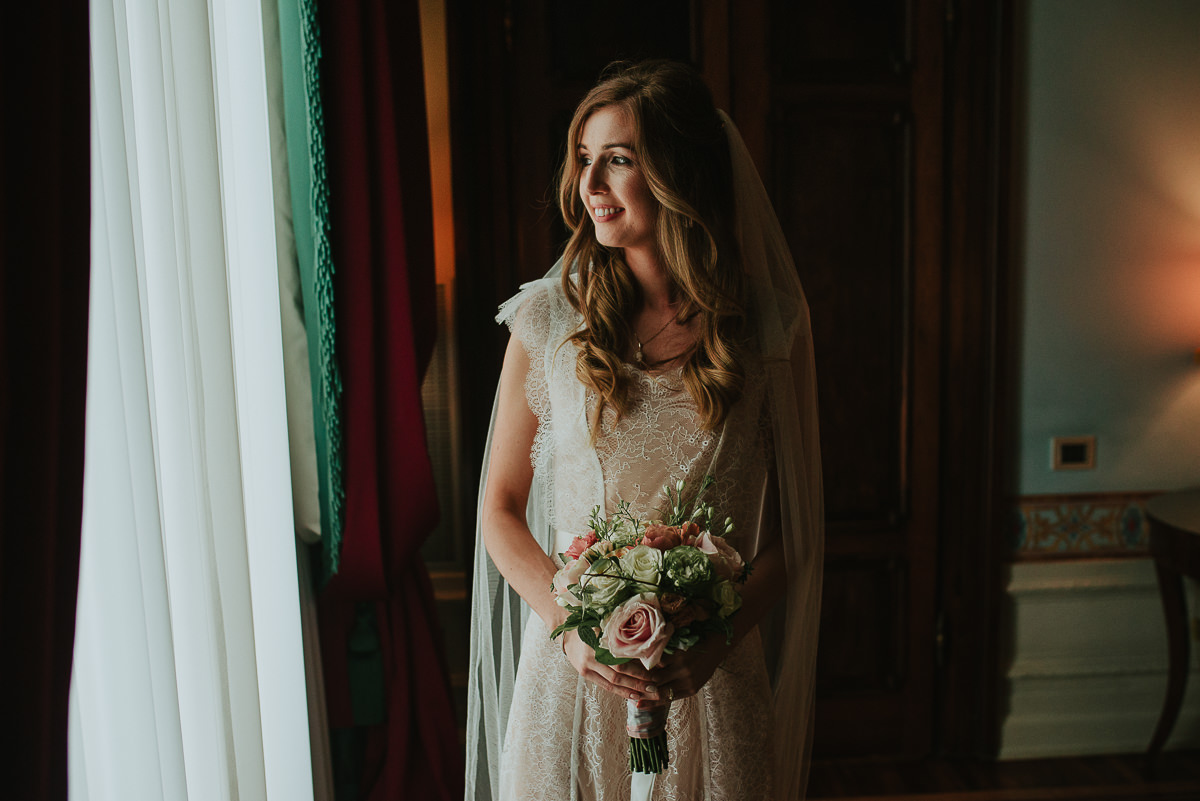 natural portrait of a bride looking out of the window in Villa Cora