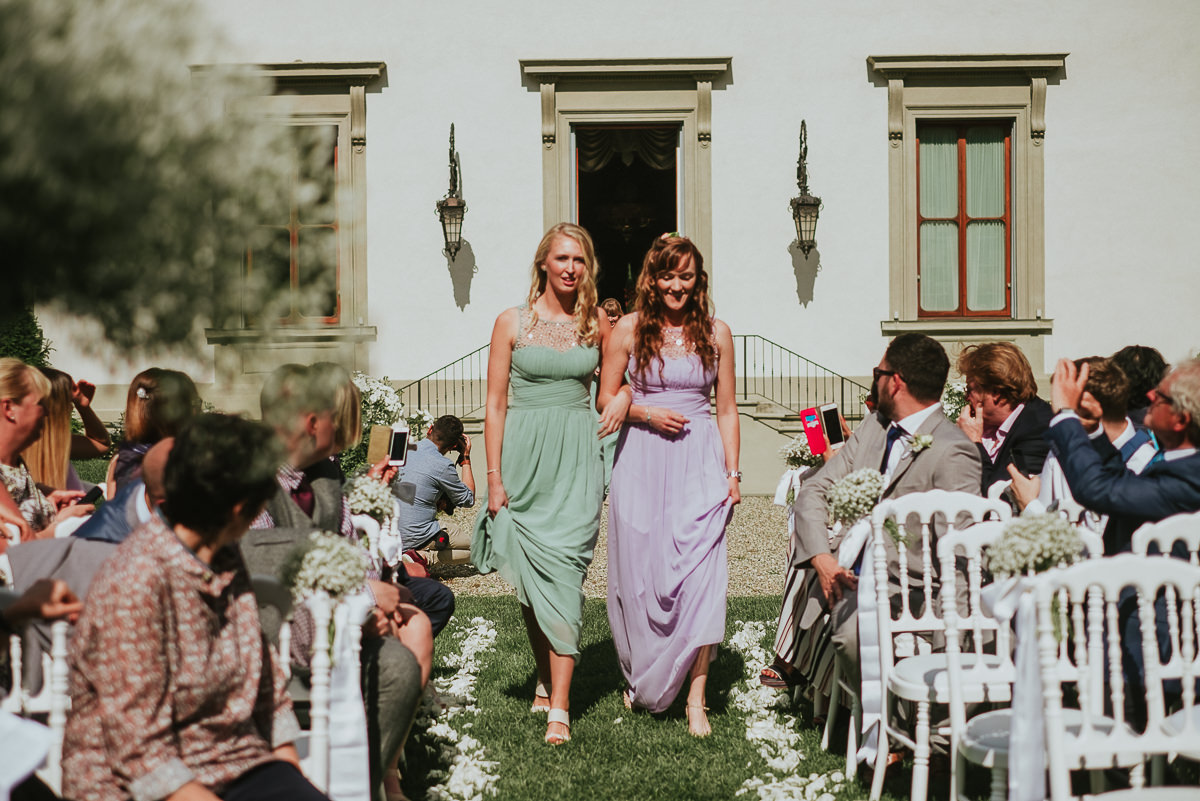 bridesmaids with pastel colours dresses walking down gardens of Villa Cora