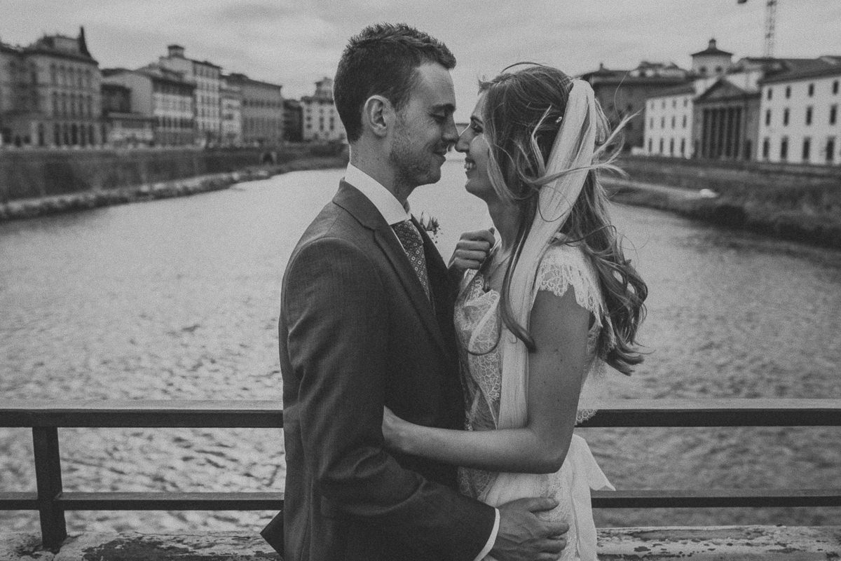 black and white portrait of bride and groom in front of Ponte Vecchio in Florence during a destination wedding