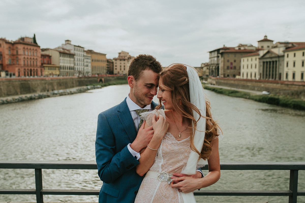 portrait of bride and groom in front of Ponte Vecchio in Florence during a destination wedding