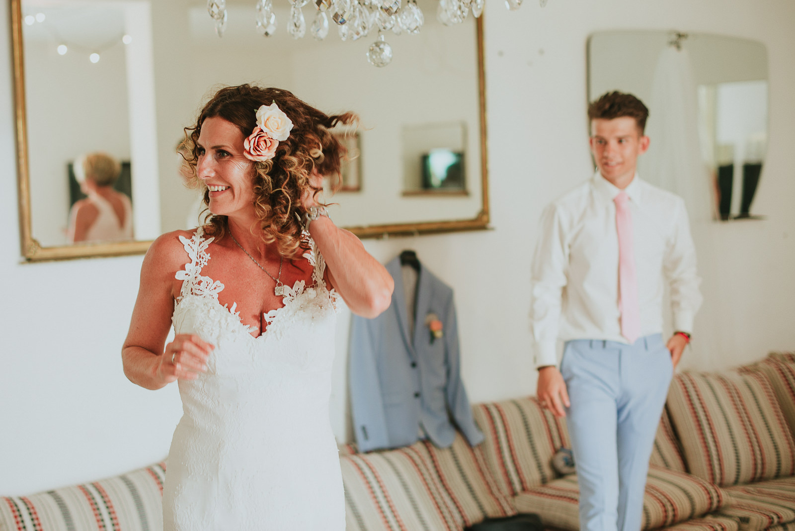 bride adjusting her hair before wedding and looking at the mirror
