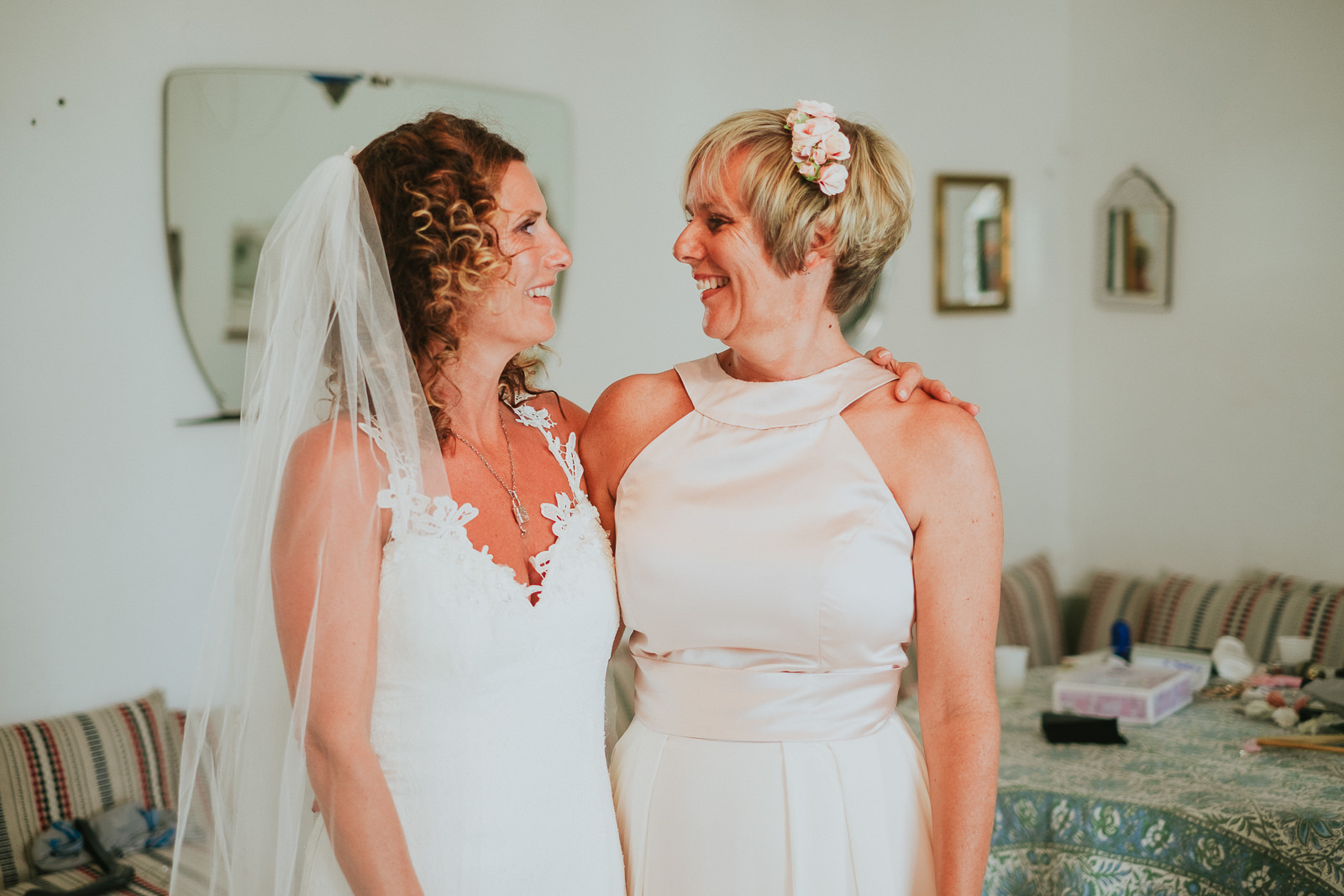 bride and her sister bridesmaid looking at each other