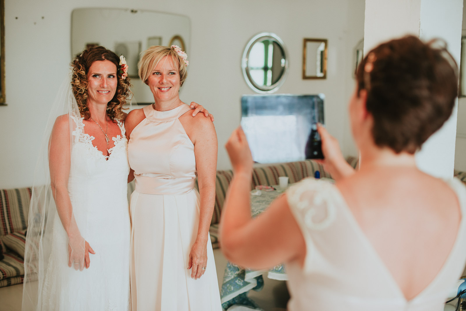 bride taking a picture with her sister before leaving for the wedding