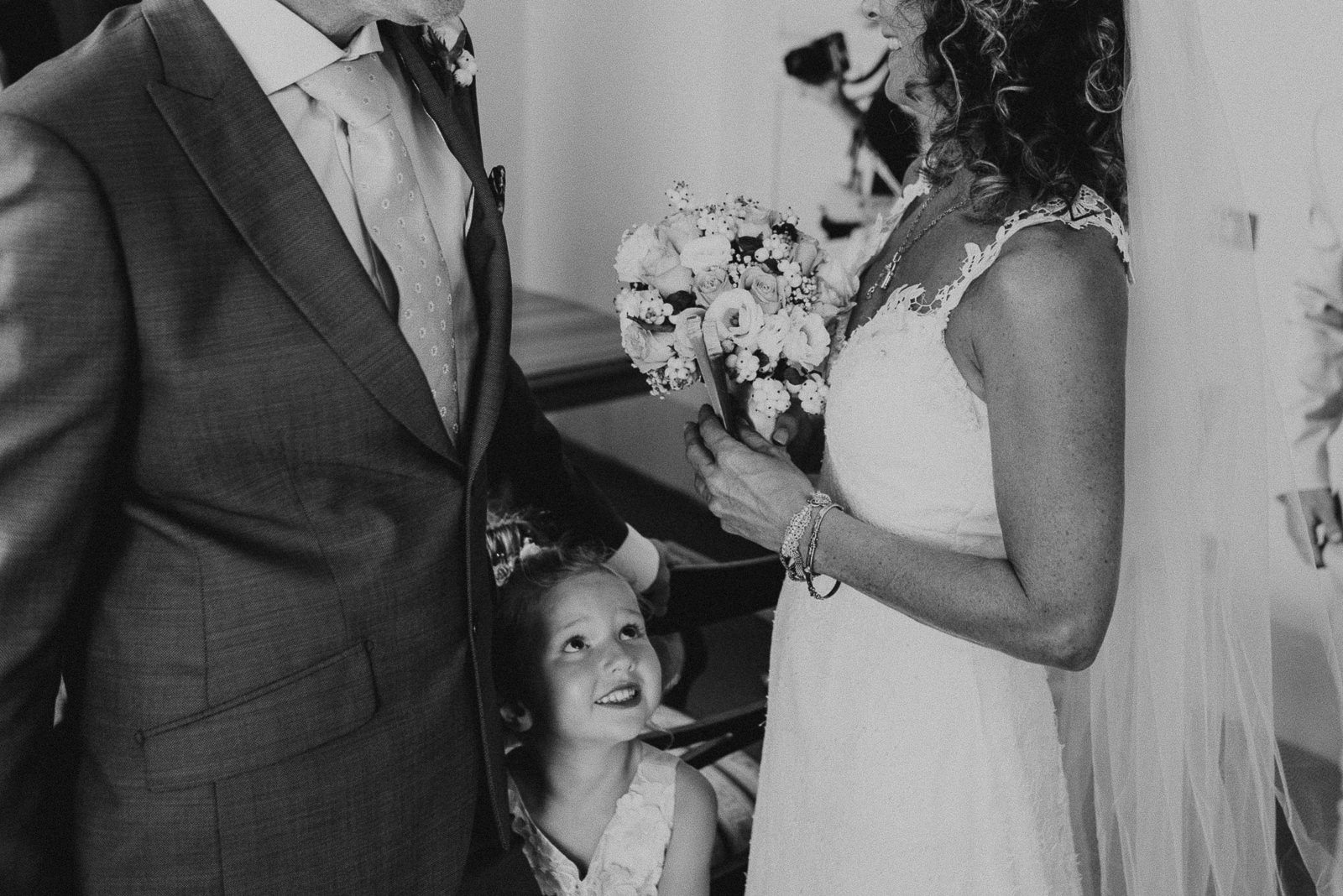 black and white portrait of flower girl looking at the bride