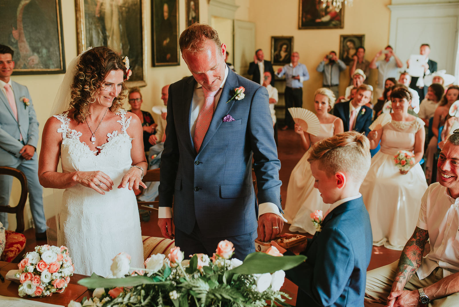 Ring bearer boy gives wedding rings to bride and groom