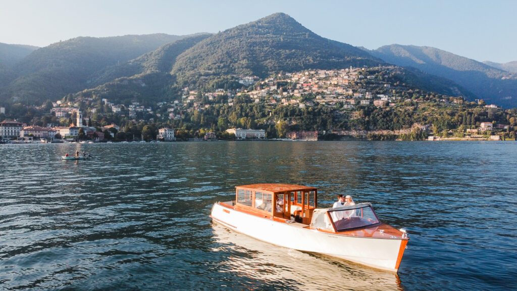 wedding couple on boat with Lake Como in distance